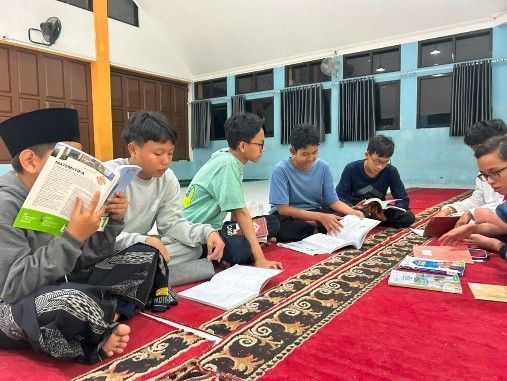 Santri membaca dan belajar bersama pada malam hari.