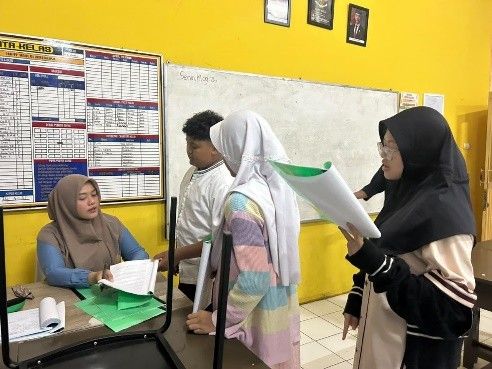 Santri putri menyetorkan hafalan doa kepada guru.