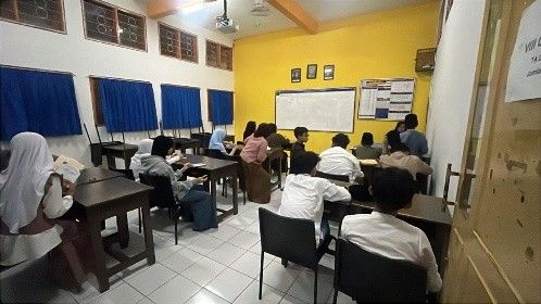 Santri mengikuti kajian kitab bersama guru di ruang kelas.