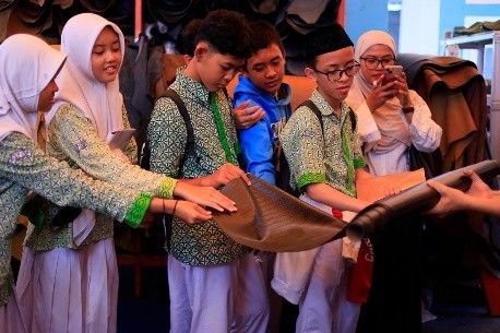 Santri mengamati produk kulit saat kunjungan kewirausahaan.