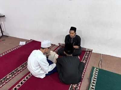 Kelompok santri putra menyimak bacaan Al-Quran.