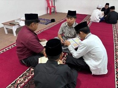 Santri putra membaca Al-Quran di hadapan pembimbing.
