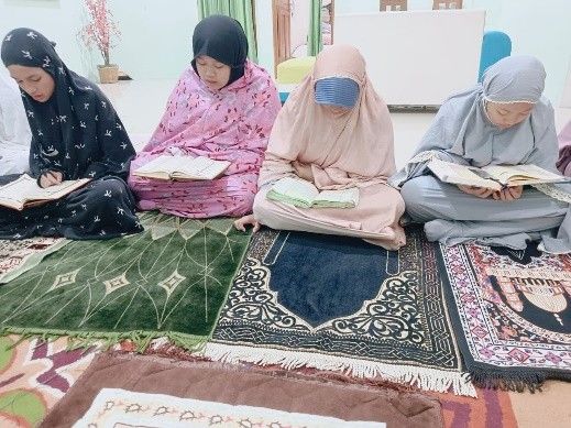 Santri putri membaca Al-Quran bersama dalam kegiatan Yasinan.