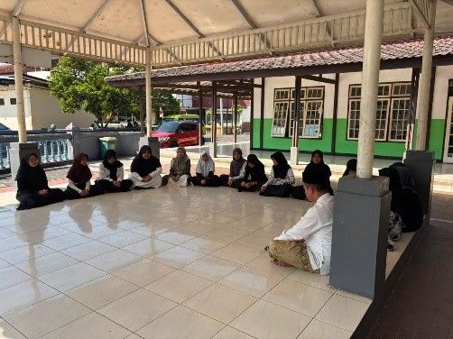 Santri dan pembimbing duduk bersama dalam kegiatan ziarah.